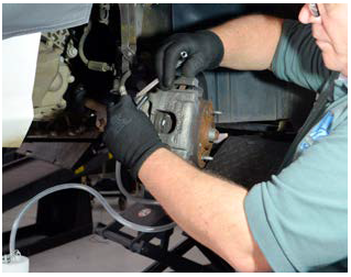 Instalar o recipiente para o fluido do freio. Soltar o flexível com a chave estrela.